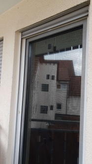 Eine Sonnenschutzfolie hinter einem Fliegengitter an einer Terassentür
