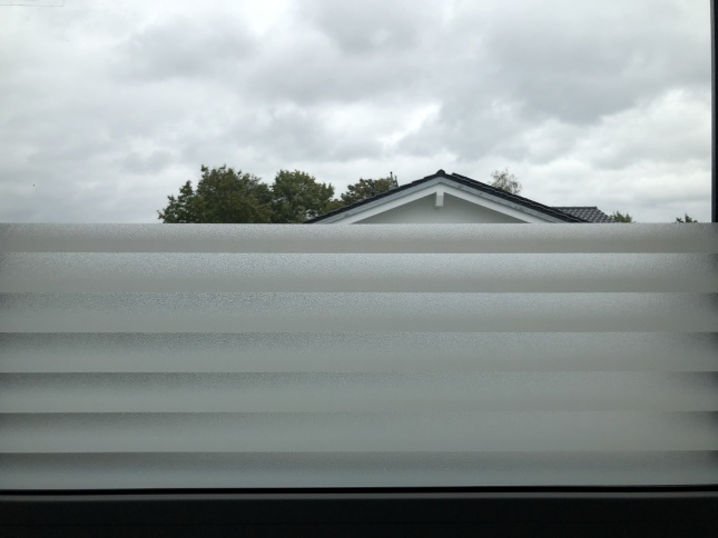 Selbsthaftende kleberlose Adhäsionsfolie im Streifendesign halbhoch auf Fenster montiert