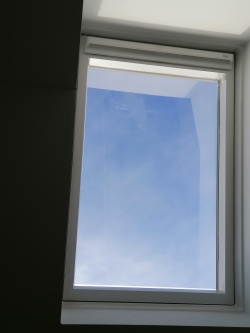 Sonnenschutzfolie mittel verspiegelt auf einem Dachfenster