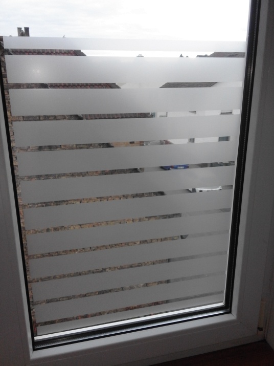 Dekorfolie mit weiß matten Streifen als Sichtschutz auf einem Fenster