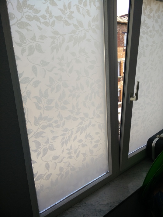 Sichtschutzfolie weiße Blätter auf weißem Grund am Fenster angebracht