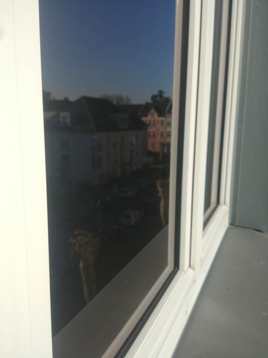 Außenansicht der Sonnenschutzfolie bronze dunkel verspiegelt an einer Fensterscheibe